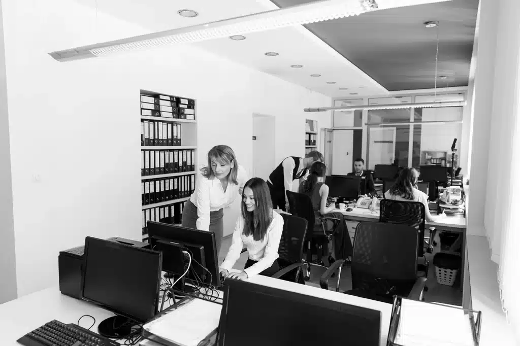 Foto von mehreren Personen die gemeinsam in einem Büro arbeiten.